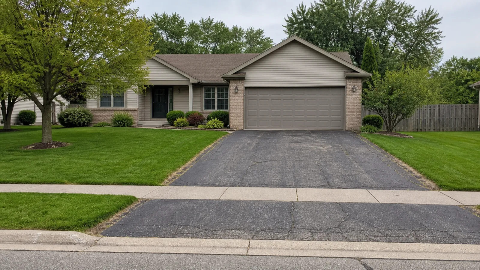 Sample property with an older cracked asphalt driveway